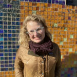 Headshot of Gretchen in front of a colorful background